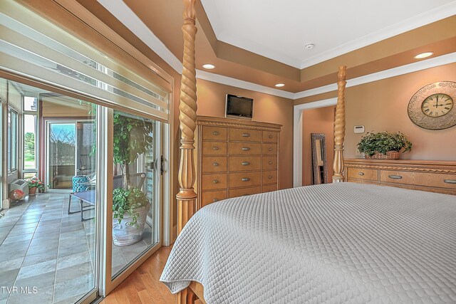 bedroom featuring a raised ceiling, access to exterior, crown molding, and light wood-type flooring