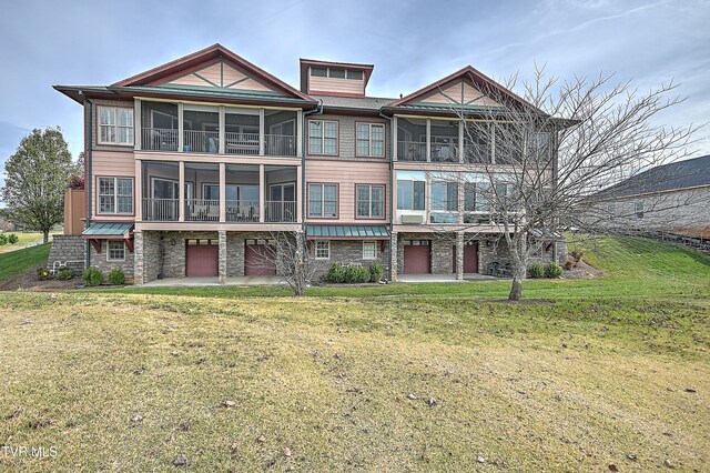 view of front of property with a garage, a patio, and a front yard