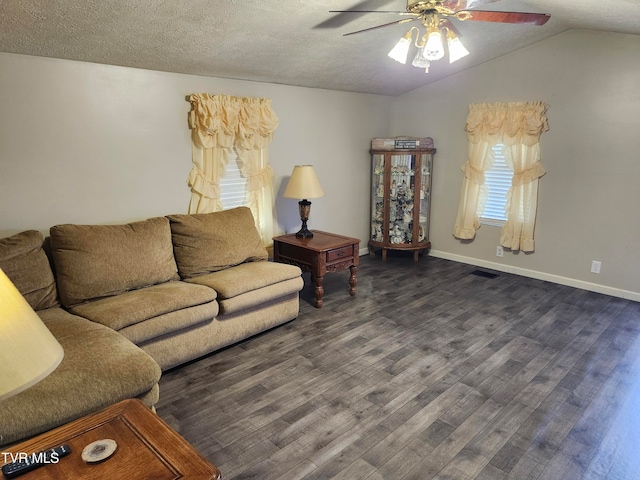 living room with a textured ceiling, ceiling fan, dark wood-type flooring, and vaulted ceiling