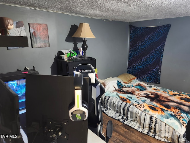 bedroom with wood-type flooring and a textured ceiling