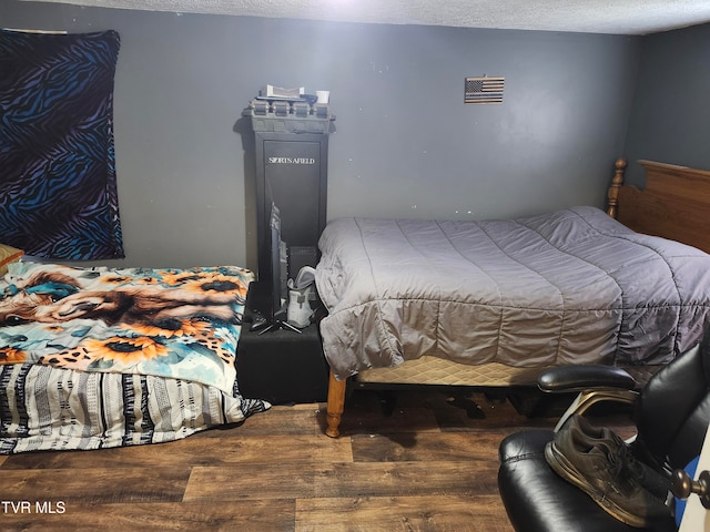 bedroom with hardwood / wood-style floors and a textured ceiling