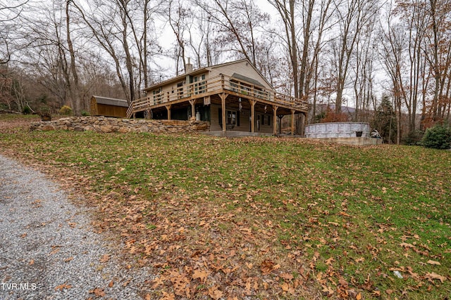 rear view of property with a yard and a deck