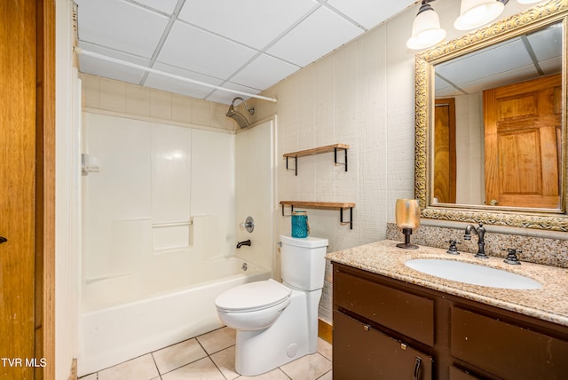 full bathroom featuring a drop ceiling, vanity, shower / tub combination, tile patterned flooring, and toilet