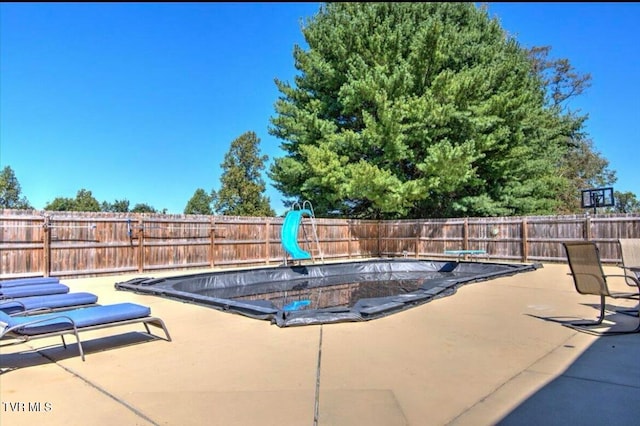 view of swimming pool featuring a patio area and a water slide