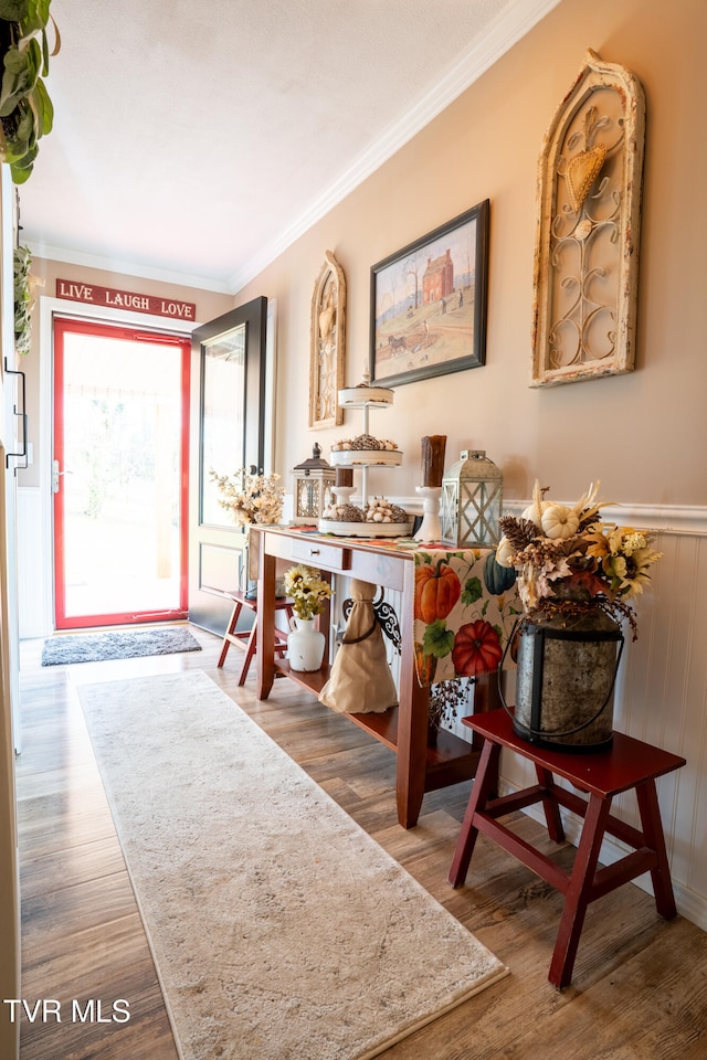 interior space with wooden walls, ornamental molding, and hardwood / wood-style flooring