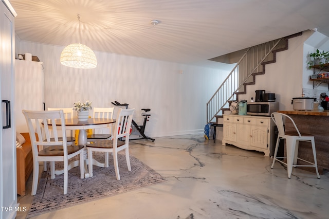 dining area with concrete floors and an inviting chandelier