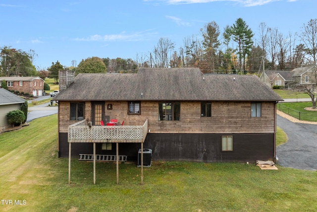 rear view of house with a yard, central AC, and a wooden deck