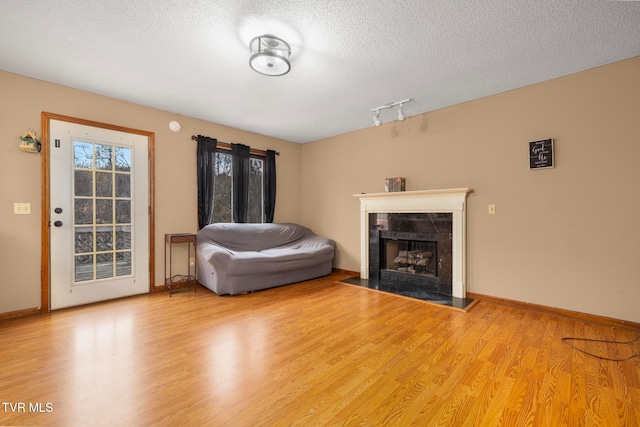 unfurnished living room featuring a textured ceiling and light wood-type flooring