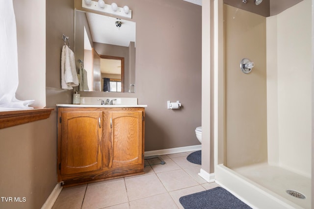 bathroom featuring toilet, a shower, vanity, and tile patterned floors