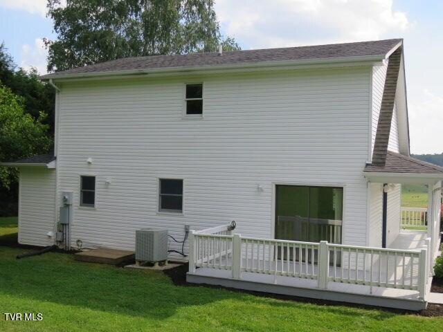 rear view of house featuring a lawn, a wooden deck, and central AC