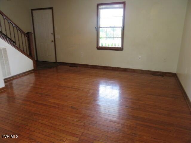 spare room featuring dark wood-type flooring