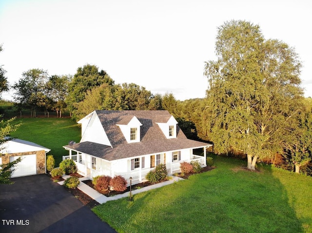 view of front of home with a garage, covered porch, and a front lawn