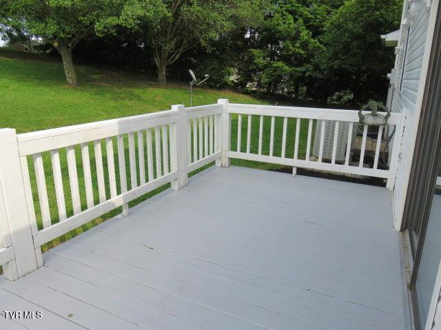 wooden terrace featuring a lawn