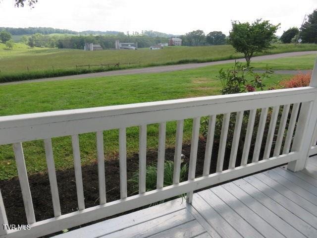 deck featuring a rural view and a lawn