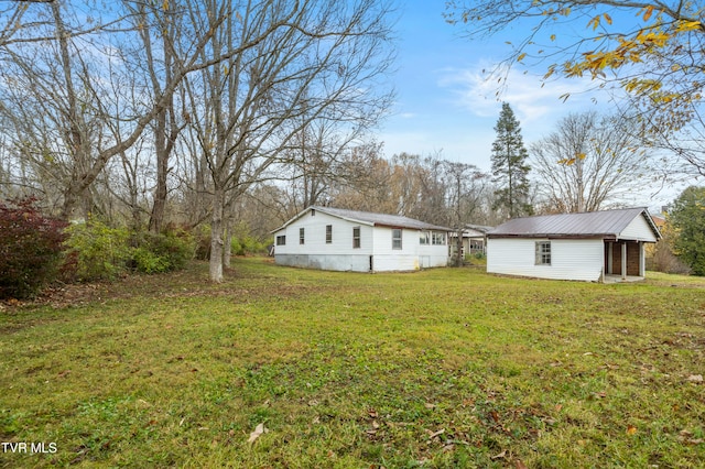 back of property with a yard and an outbuilding