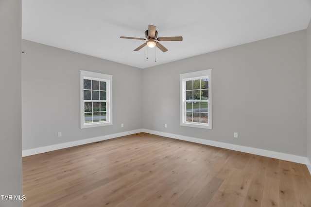 spare room featuring light hardwood / wood-style flooring, ceiling fan, and a healthy amount of sunlight