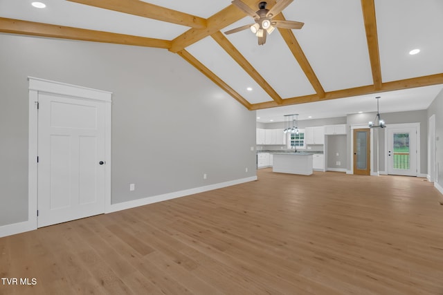 unfurnished living room with beamed ceiling, a healthy amount of sunlight, and light wood-type flooring