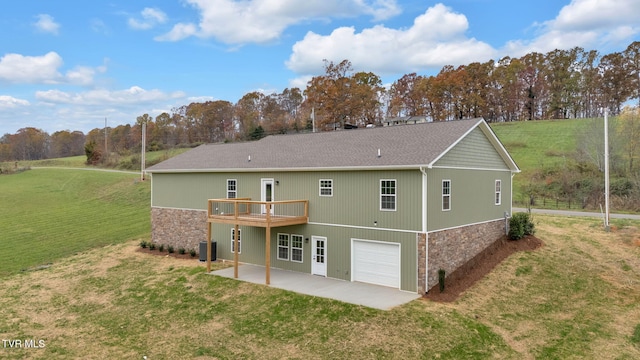 back of property with a garage, a yard, central AC unit, a patio area, and a deck