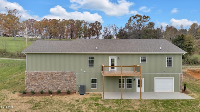 back of house featuring a deck, central air condition unit, a patio, a garage, and a lawn