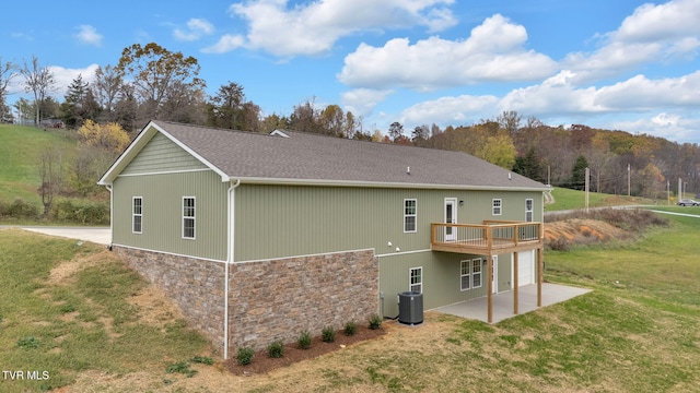 rear view of property featuring a yard, a patio, central AC, and a deck