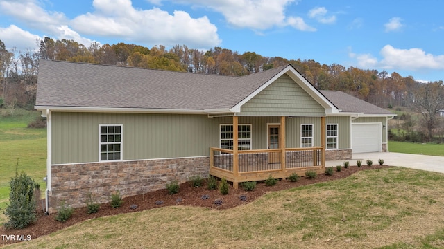 view of front of home featuring a front yard, a porch, and a garage