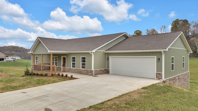 view of front of house featuring a garage, covered porch, and a front lawn