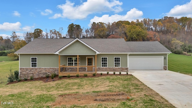 view of front facade with a front lawn, covered porch, and a garage