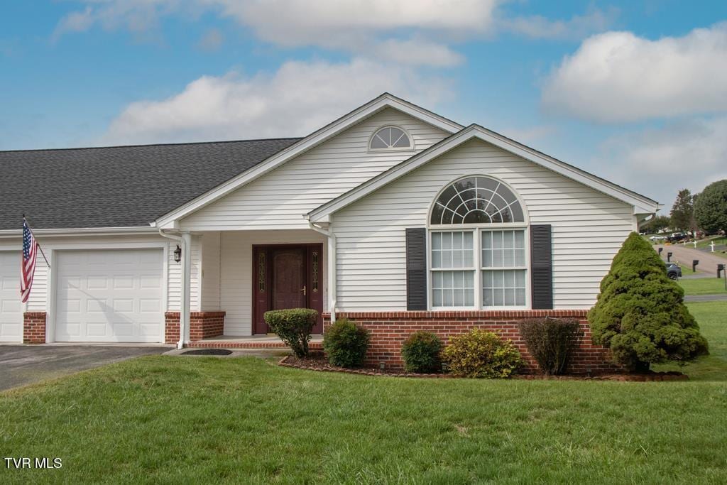 ranch-style house featuring a garage and a front yard