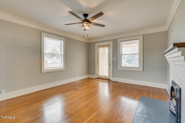 unfurnished living room with crown molding, a fireplace, ceiling fan, and hardwood / wood-style flooring