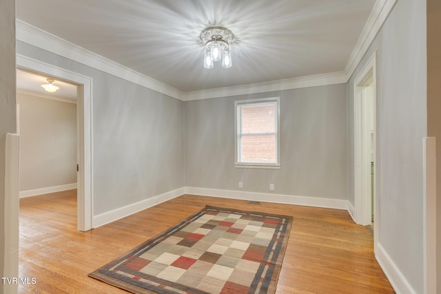 empty room featuring crown molding and light hardwood / wood-style flooring