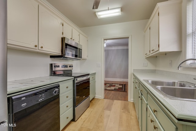 kitchen with light wood-type flooring, stainless steel appliances, green cabinetry, and sink