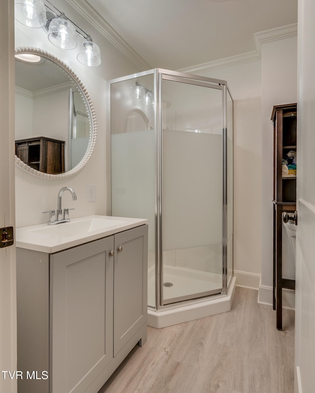 bathroom featuring hardwood / wood-style floors, vanity, an enclosed shower, and crown molding