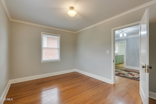 empty room with wood-type flooring and ornamental molding