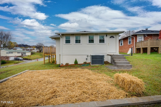 view of front of property featuring a wooden deck, cooling unit, and a front yard