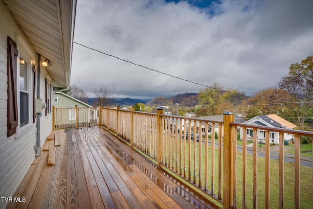 wooden terrace with a lawn and a mountain view