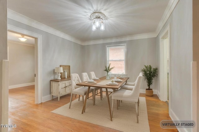 dining space featuring light wood-type flooring and ornamental molding