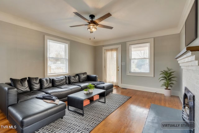 living room with wood-type flooring, ceiling fan, and ornamental molding