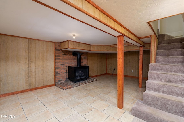 basement with a wood stove and wooden walls