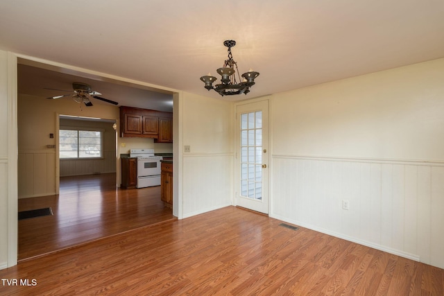 interior space featuring hardwood / wood-style floors and ceiling fan with notable chandelier