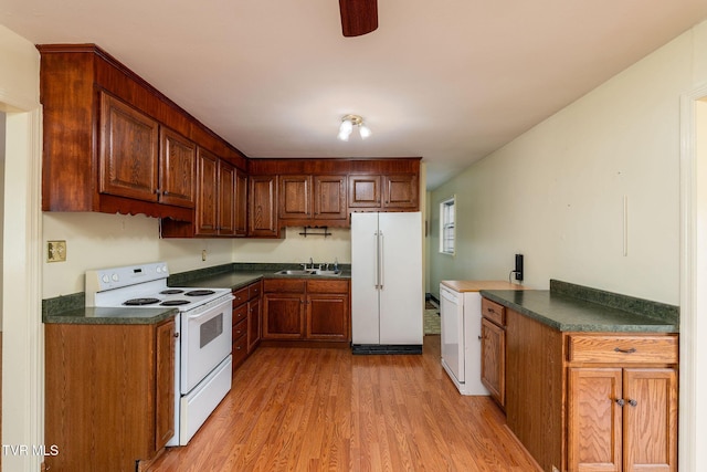 kitchen with electric range, white refrigerator, sink, and light hardwood / wood-style flooring