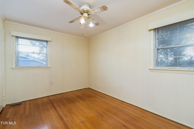 empty room with hardwood / wood-style flooring, ceiling fan, and crown molding