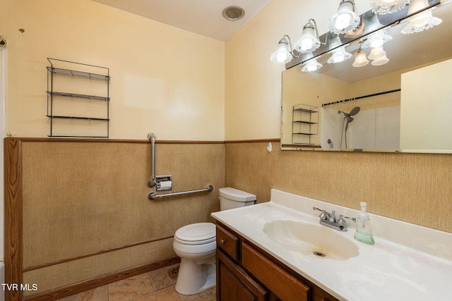 bathroom with tile patterned flooring, a shower, vanity, and toilet