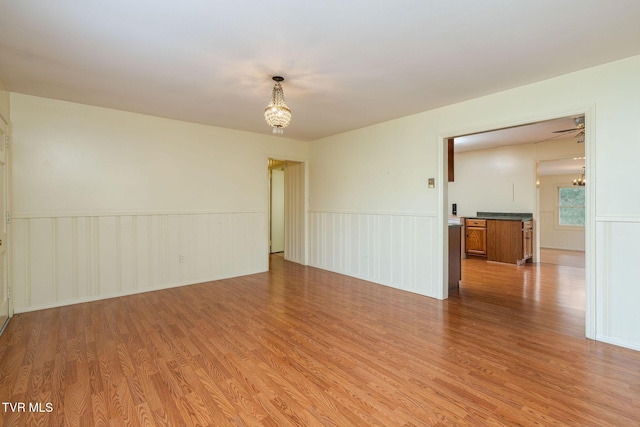 unfurnished room featuring light hardwood / wood-style flooring and an inviting chandelier