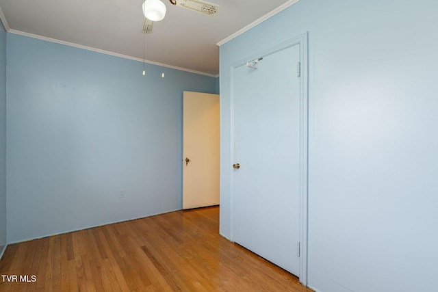 unfurnished bedroom with light wood-type flooring, a closet, ornamental molding, and ceiling fan