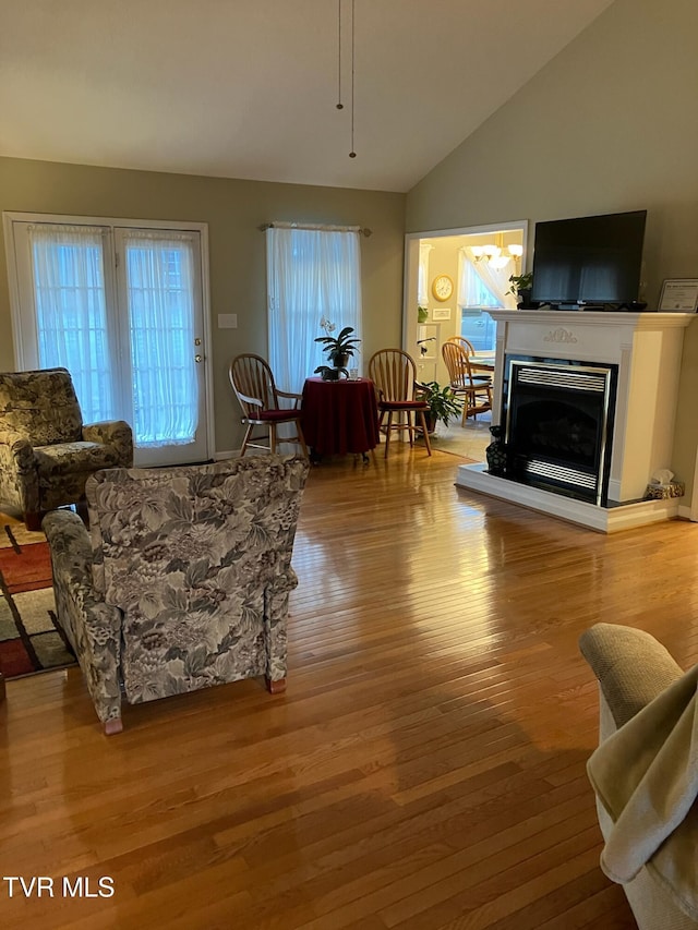 living room with light hardwood / wood-style floors, a wealth of natural light, and lofted ceiling