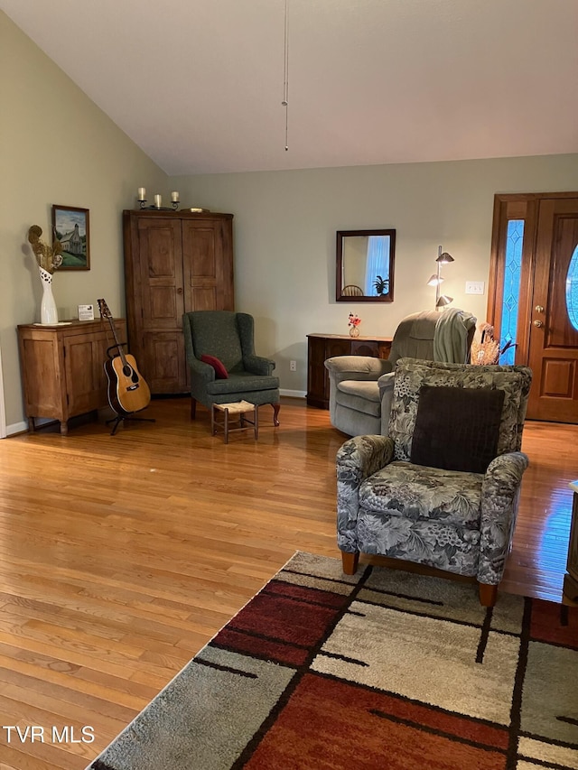 living room with light hardwood / wood-style flooring and lofted ceiling