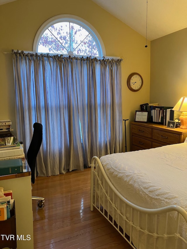 bedroom with wood-type flooring and vaulted ceiling