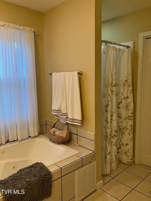 bathroom featuring tile patterned flooring, a tub, and a textured ceiling