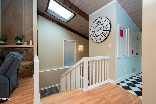 stairs featuring hardwood / wood-style flooring, wooden ceiling, and lofted ceiling with skylight