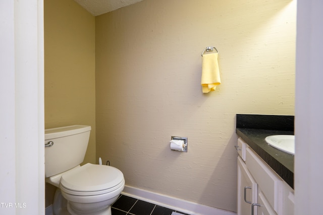 bathroom featuring tile patterned floors, vanity, toilet, and a textured ceiling